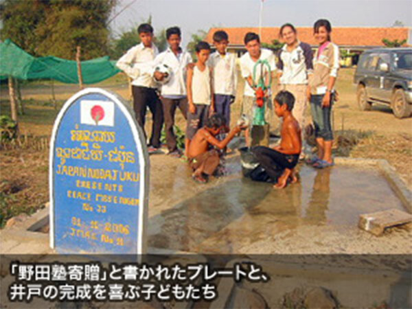 「野田塾寄贈」と書かれたプレートと、井戸の完成を喜ぶ子どもたち